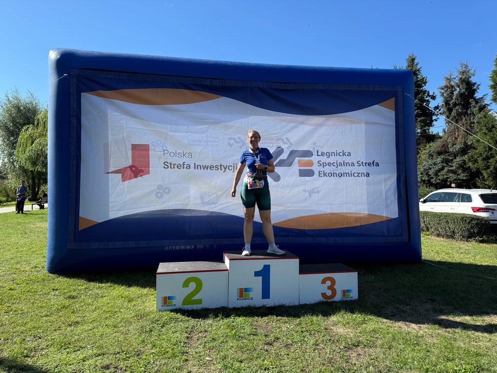 podium, ścianka dmuchana LSSE, polana, pracownik LSSE na podium