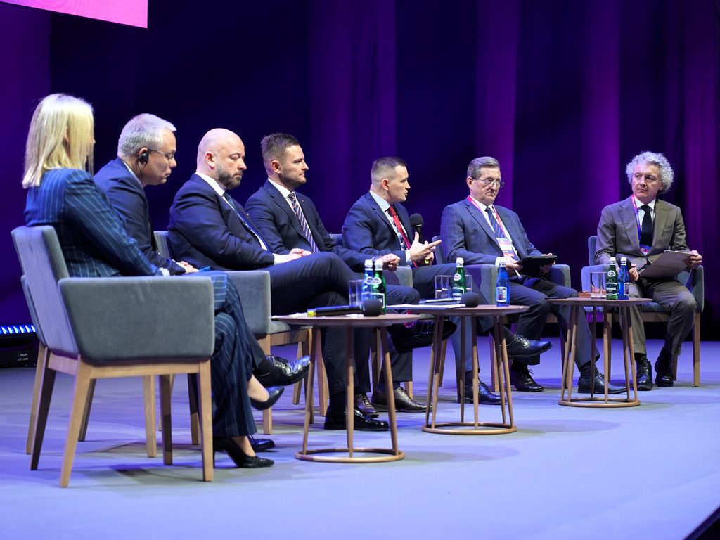 panel dyskusyjny, ludzie siedzą na scenie, minister