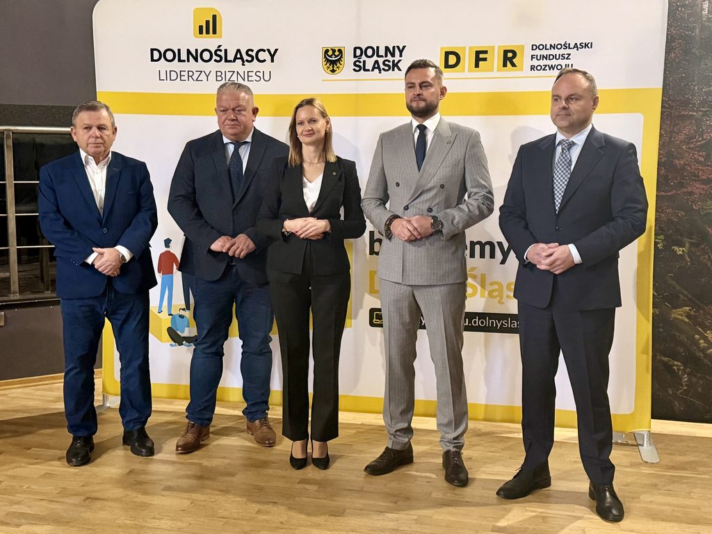 konferencja prasowa, grupa ludzi pozuje do zdjęcia na ściance
